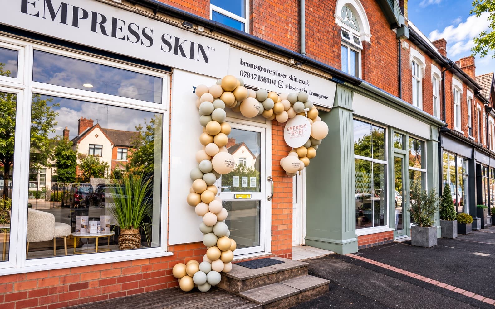 The storefront of a clinic decorated with a balloon arch on its opening day